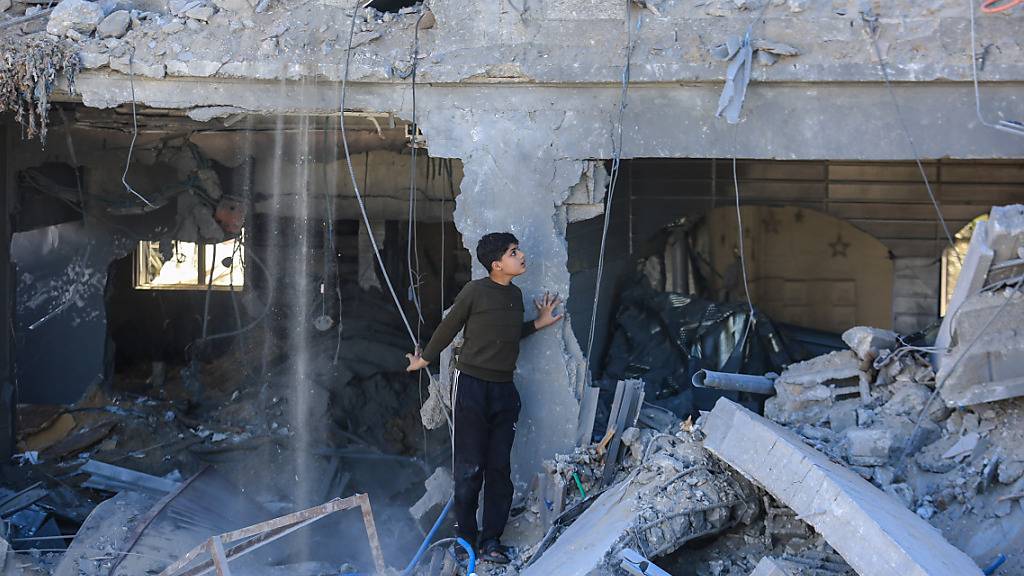 dpatopbilder - Ein Kind steht zwischen zerstörten Gebäuden nach einem israelischen Angriff. Foto: Mohammed Talatene/dpa