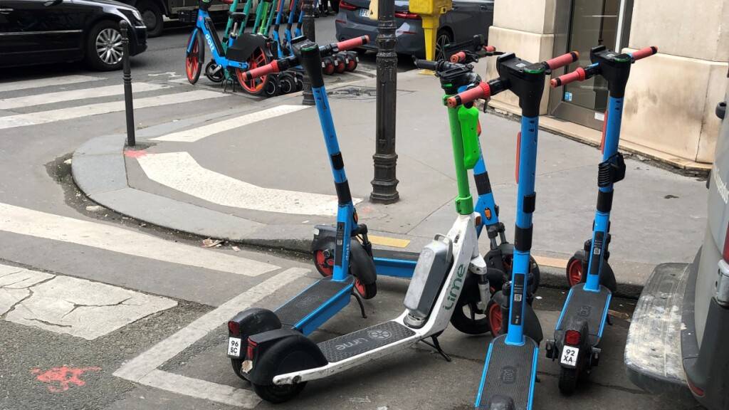 ARCHIV - E-Scooter von drei verschiedenen Anbietern stehen auf dafür vorgesehenen Parkplätzen. Mit der Abschaffung des E-Scooter-Verleihs nach einer Bürgerbefragung in Paris Ende August sollen die 15.000 Roller nicht verschrottet, sondern in anderen Städten eingesetzt werden. Foto: Michael Evers/dpa