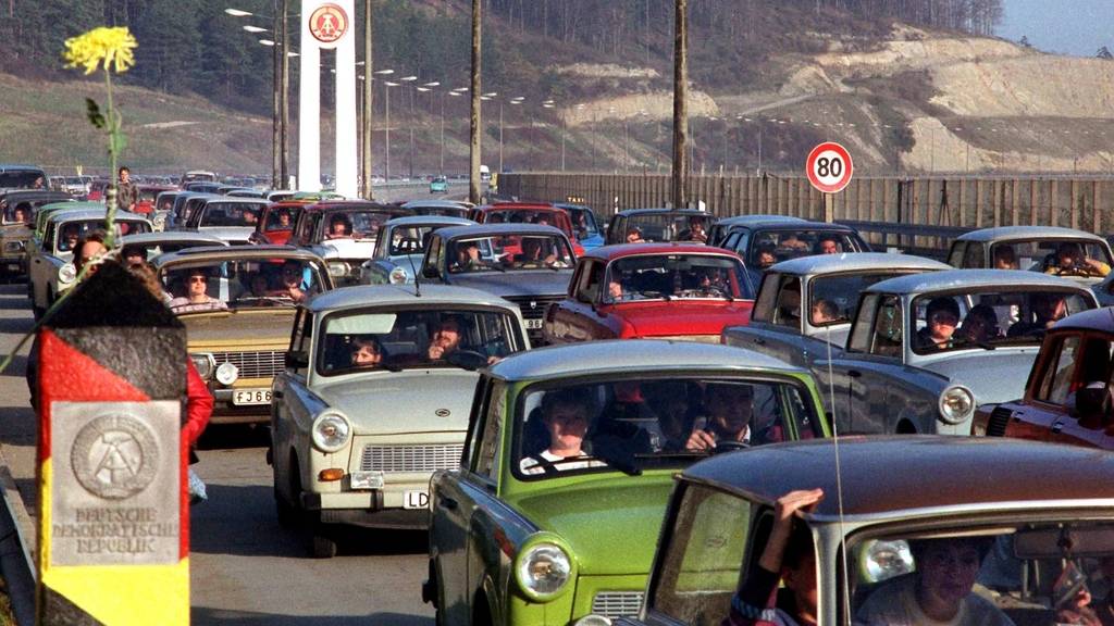 Am Grenzübergang in Richtung BRD versuchen hunderte Trabis aus der DDR zu fahren.