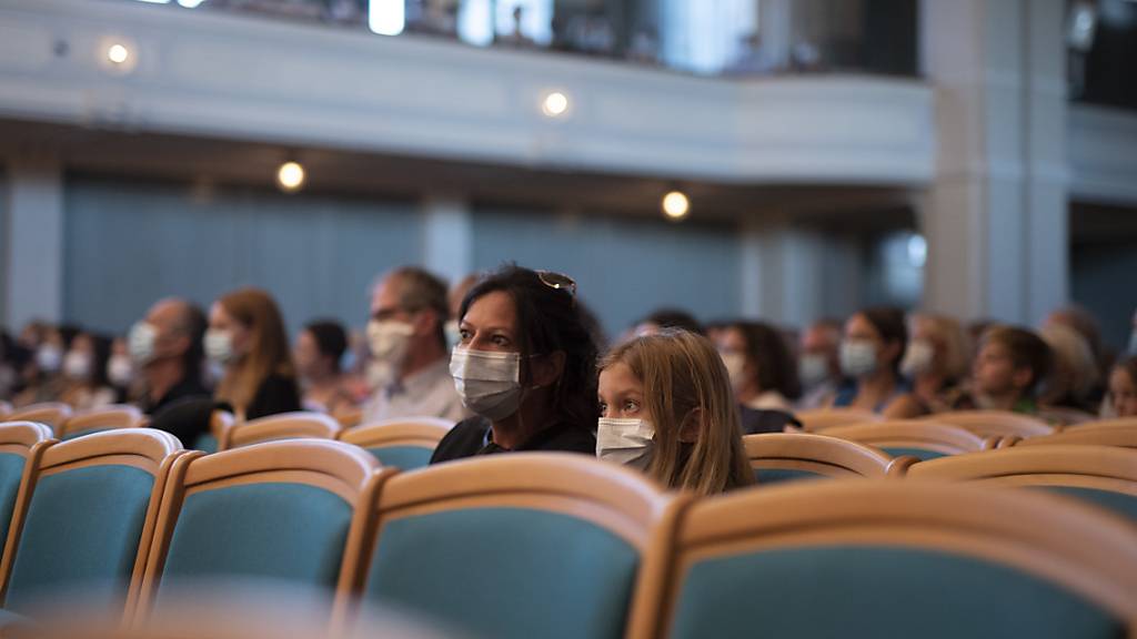 An vielen Orten geht es nicht mehr ohne: Publikum mit Schutzmasken in einem Konzertsaal. (Archivbild)