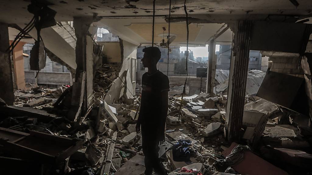 Ein Palästinenser inspiziert das beschädigte Haus eines palästinensischen Fernsehjournalisten, der zusammen mit seinen Familienangehörigen bei einem israelischen Bombenangriff getötet wurde. Foto: Mohammed Talatene/dpa