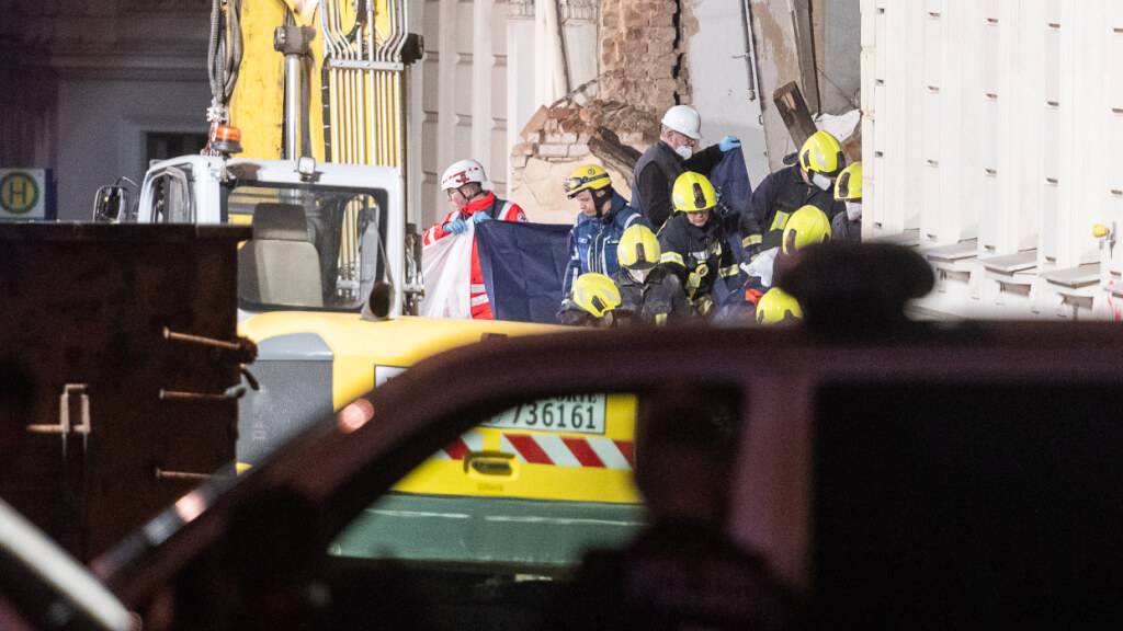 Einsatzkräfte der Feuerwehr tragen hinter Sichtschutz eine Leiche aus dem Trümmerfeld eines eingestürzten Hauses. Aufnahme aus der James-von-Moltke-Strasse in Görlitz. Hier kam es am frühen Abend des 18.5.2026 zu einem Einsturz eines bewohnten Hauses. Foto: Paul Glaser/dpa