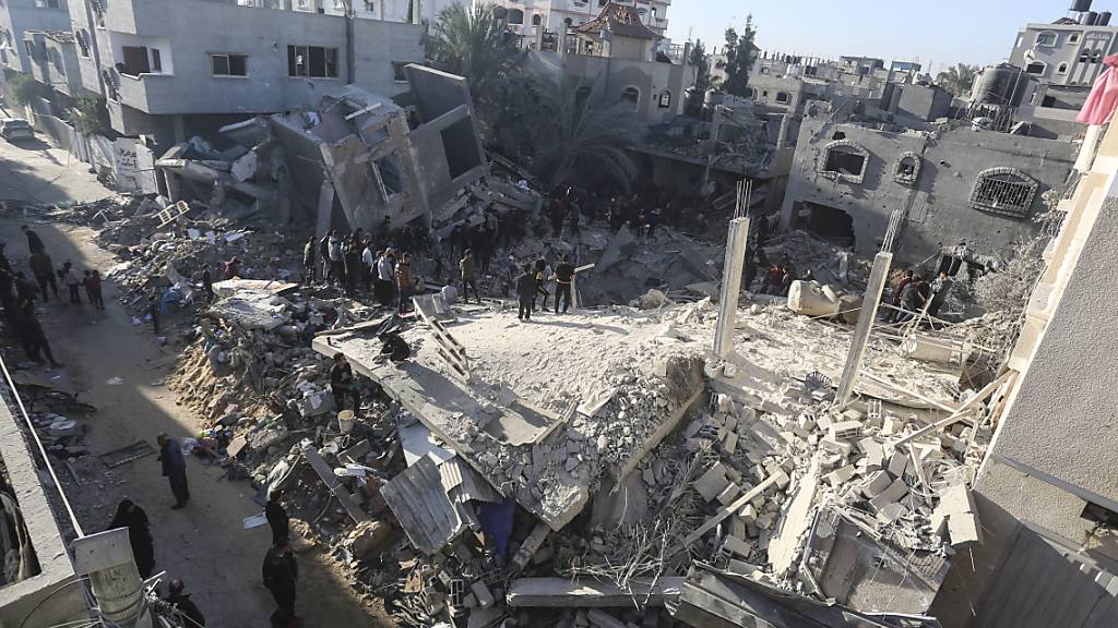 Menschen suchen in den Trümmern eines Gebäudes nach Überlebenden des israelischen Bombardements. Foto: Hatem Ali/AP