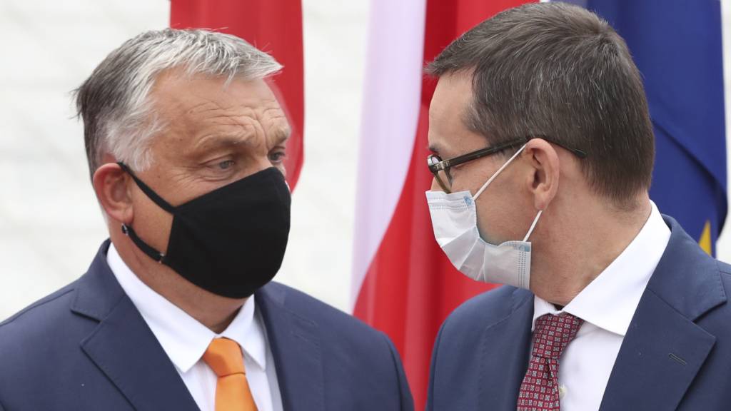Mateusz Morawiecki (r), Premierminister von Polen, trägt einen Mundschutz und begrüßt Viktor Orban, Premierminister von Ungarn, ebenfalls mit Mundschutz, zum Treffen der Premierminister der Visegrad-Staaten. Foto: Czarek Sokolowski/AP/dpa