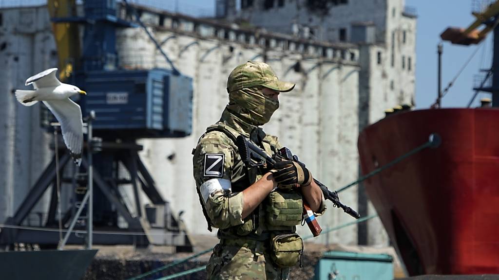 ARCHIV - Ein russischer Soldat bewacht einen Pier mit einem Getreidespeicher im Hintergrund auf dem Gelände des Seehafens von Mariupol, der nach schweren Kämpfen wieder in Betrieb genommen wurde. Foto: Uncredited/AP/dpa