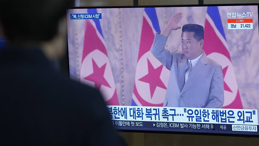 Ein Mann betrachtet einen Fernsehbildschirm in einem Bahnhof, auf dem eine Nachrichtensendung über Nordkoreas Raketen gezeigt wird.