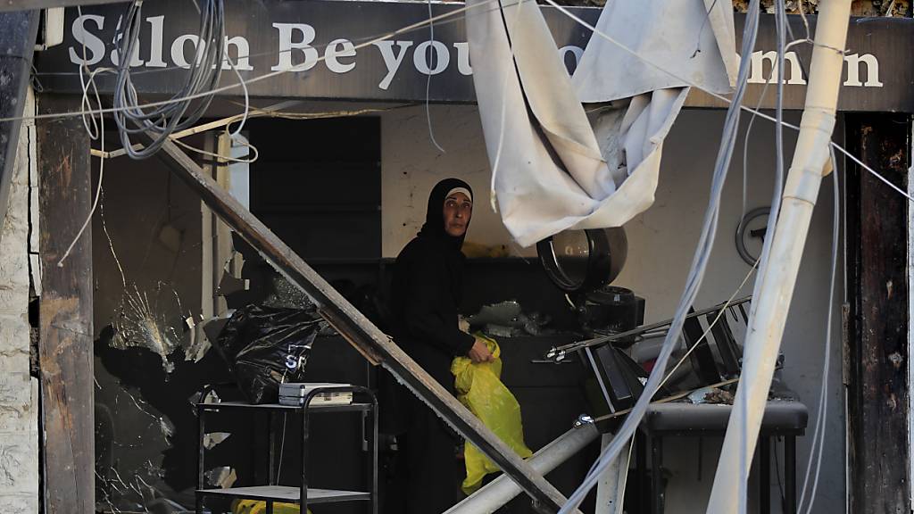 ARCHIV - Eine Frau blickt durch ihren Friseursalon, der nach israelischen Luftangriffen zerstört wurde. Foto: Mohammad Zaatari/AP/dpa