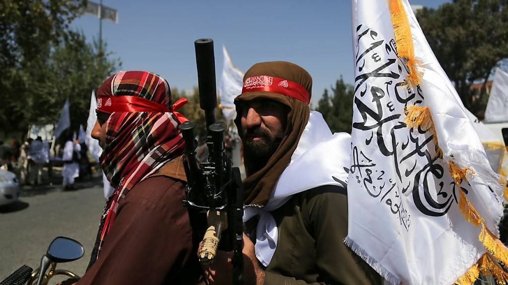 ARCHIV - Taliban schwenken Fahnen während des zweiten Jahrestags ihrer Machtübernahme. Foto: Siddiqullah Alizai/AP/dpa