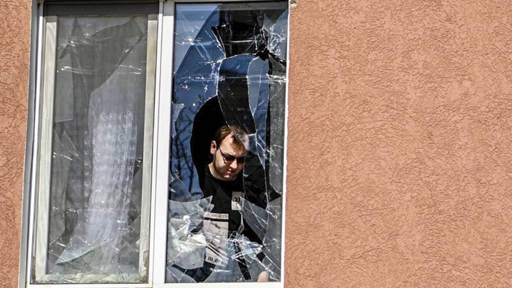 HANDOUT - Ein Mann betrachtet das zerbrochene Fenster seines Hauses nach Beschuss durch die Ukraine. Foto: Uncredited/AP/dpa - ACHTUNG: Nur zur redaktionellen Verwendung und nur mit vollständiger Nennung des vorstehenden Credits