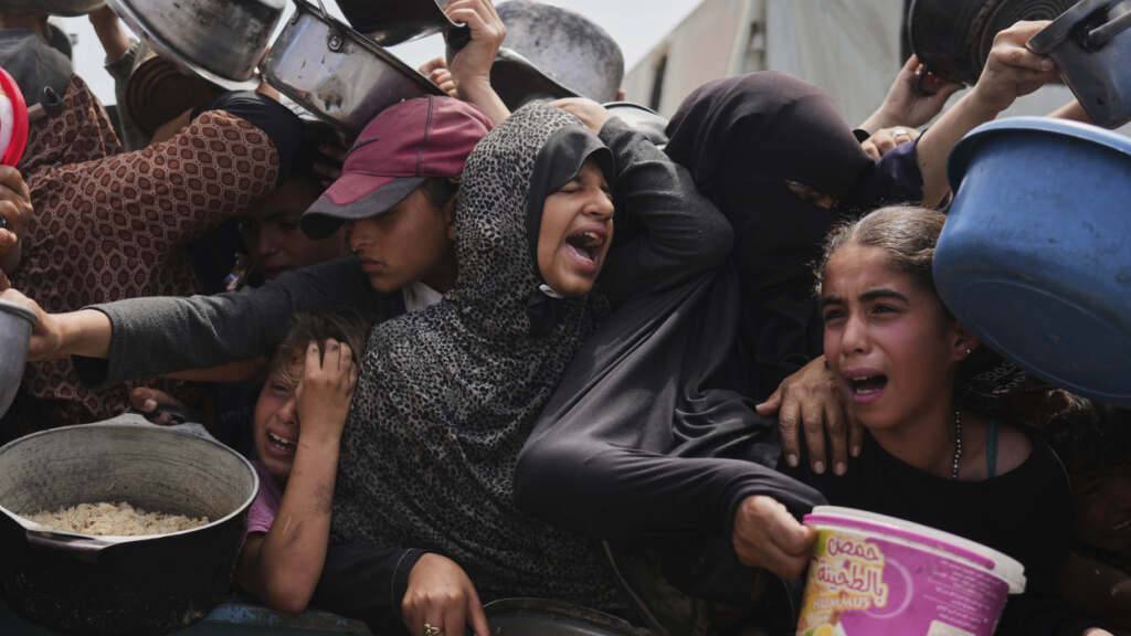 ARCHIV - Palästinensische Kinder erhalten gespendete Lebensmittel in einem Verteilungszentrum in Chan Junis, Gazastreifen. Foto: Abdel Kareem Hana/AP/dpa