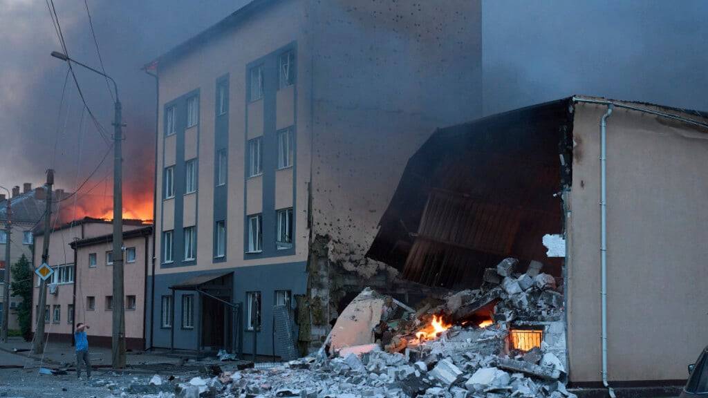 dpatopbilder - Nach einem russischen Raketen- und Drohnenangriff steigen Feuer und Rauch über beschädigten Gebäuden auf. Foto: Efrem Lukatsky/AP/dpa