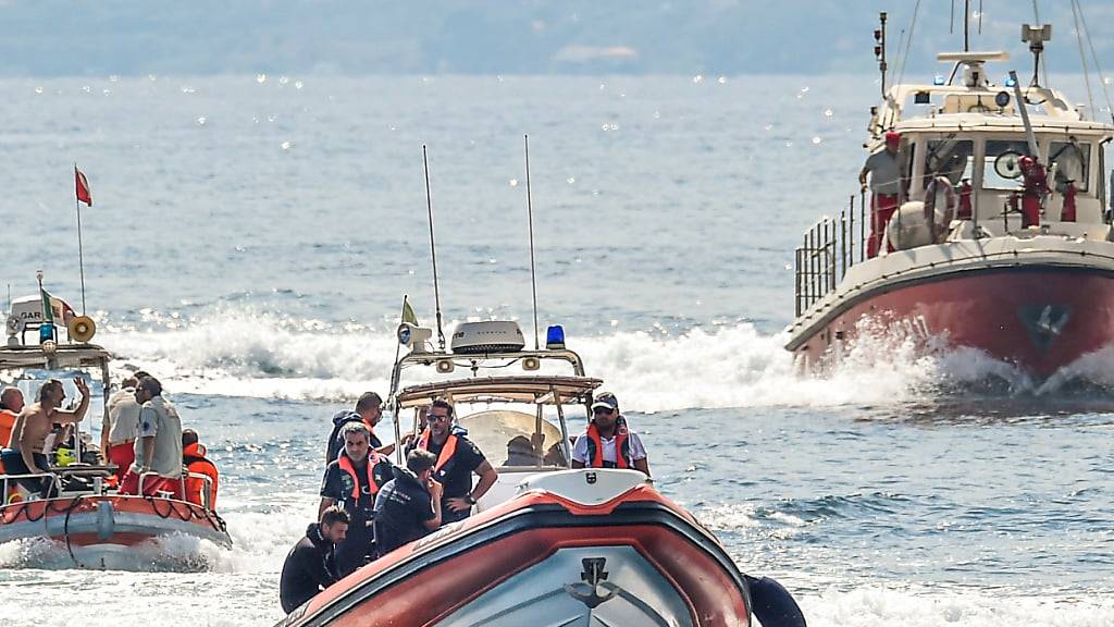 Italienische Taucher der Feuerwehr arbeiten an der Stelle eines Schiffswracks. Foto: Salvatore Cavalli/AP/dpa