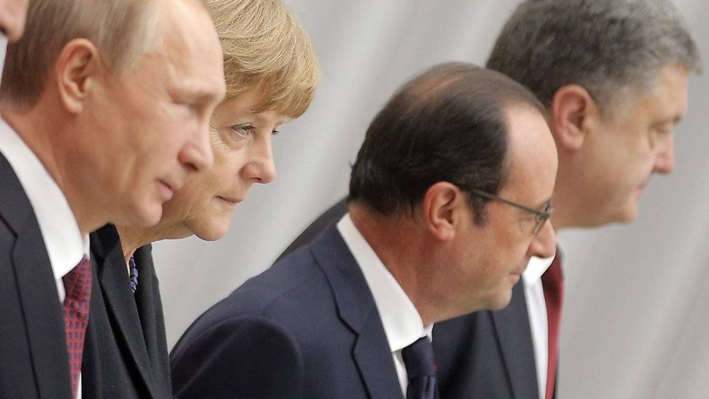 Steckten die Köpfe über den Ukraine-Konflikt zusammen: Putin, Merkel, Hollande und Poroschenko sprechen sich per Telefon ab. (Archivbild)