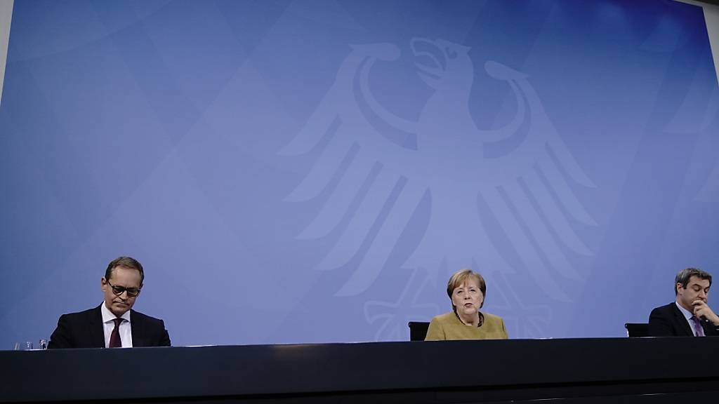 Bundeskanzlerin Angela Merkel (CDU), nimmt neben Markus Söder (CSU, r), Ministerpräsident von Bayern und CSU-Vorsitzender, sowie Michael Müller (SPD), Regierender Bürgermeister von Berlin, an der Pressekonferenz nach den Beratungen von Bund und Ländern teil. Foto: Michael Kappeler/dpa-pool/dpa