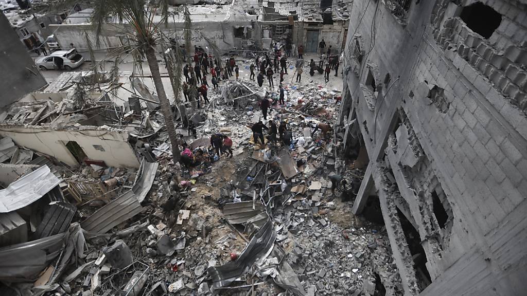 Palästinenser betrachten die Zerstörung nach einem israelischen Angriff. Foto: Mohammed Dahman/AP/dpa