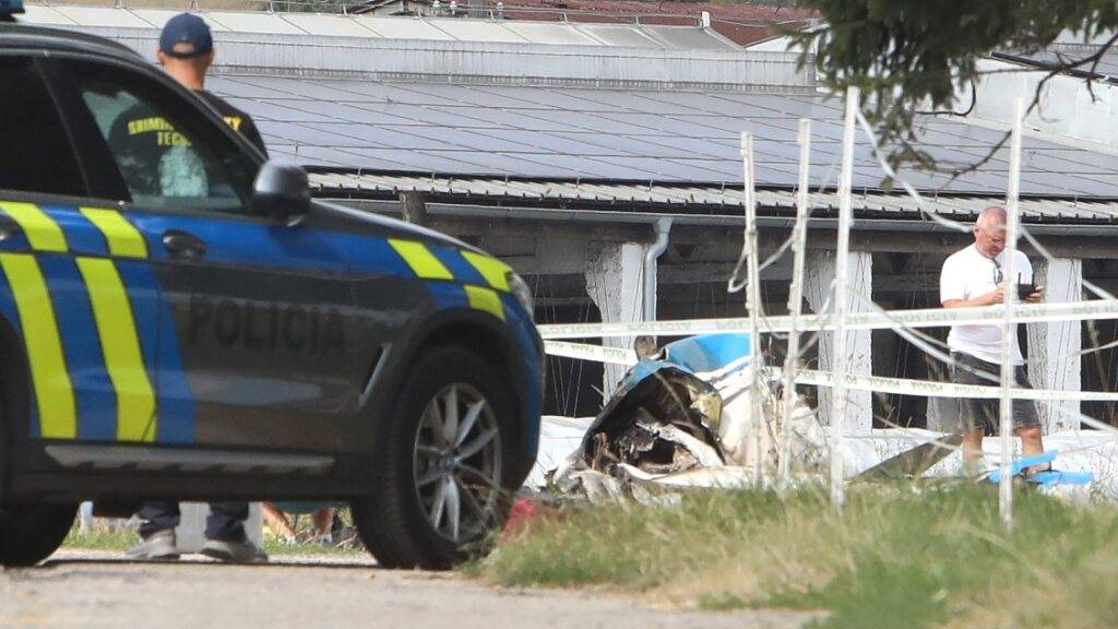Polizisten und Feuerwehrleute stehen an der Absturzstelle eines Kleinflugzeugs nahe Ocová im Bezirk Zvolen. Beim Absturz eines Kleinflugzeugs in der Slowakei sind zwei Erwachsene und eine minderjährige Person gestorben. Foto: Ján Kro·lák/TASR/dpa
