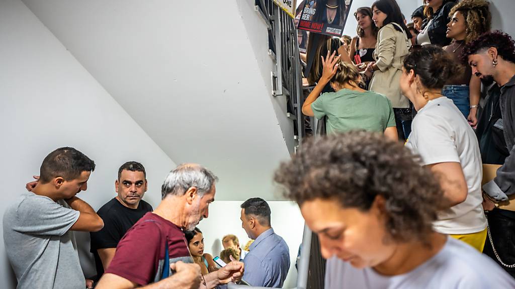 Passanten und Besucher der Deutschen Botschaft stehen während eines Luftalarms in einem Schutzraum. Foto: Michael Kappeler/dpa