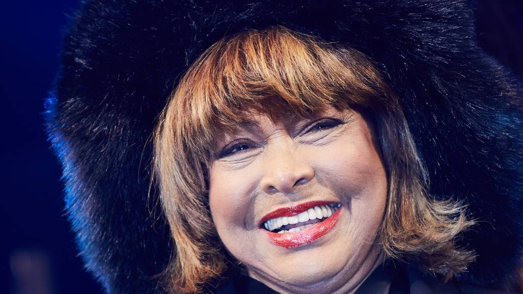 lachende Tina Turner mit Kapuze mit Fellrand
