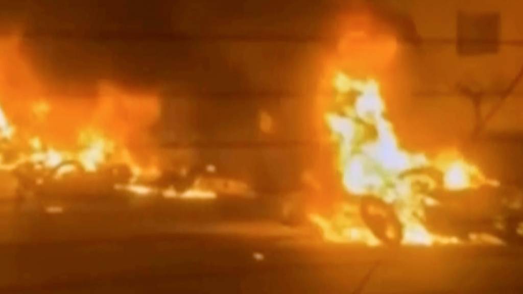 HANDOUT - Dieses Videostandbild aus dem iranischen Staatsfernsehen zeigt brennende Fahrzeuge während nächtlicher Massenproteste. Foto: Uncredited/Iran state TV/AP/dpa - ACHTUNG: Nur zur redaktionellen Verwendung im Zusammenhang mit der aktuellen Berichterstattung und nur mit vollständiger Nennung des vorstehenden Credits