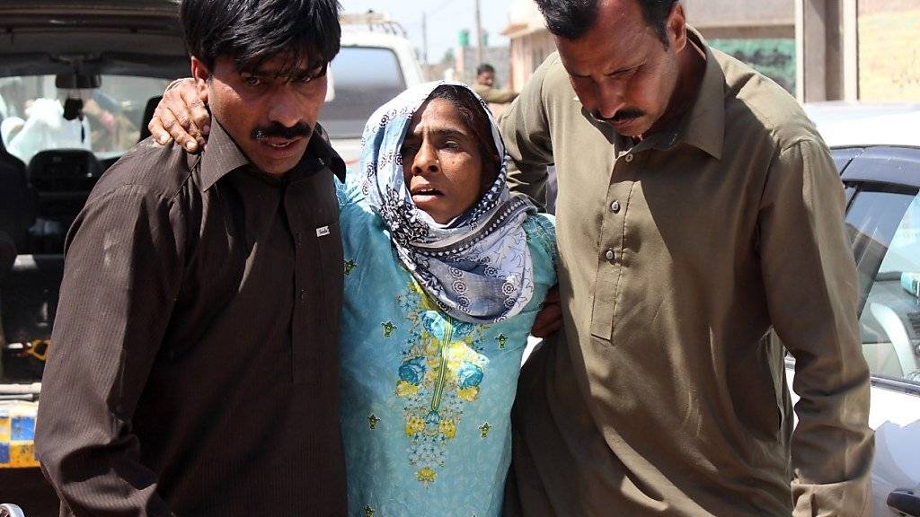 Nach dem Blutbad in einem Sufi-Schrein in Pakistan warten Angehörige auf die Herausgabe der Leichen der Opfer.