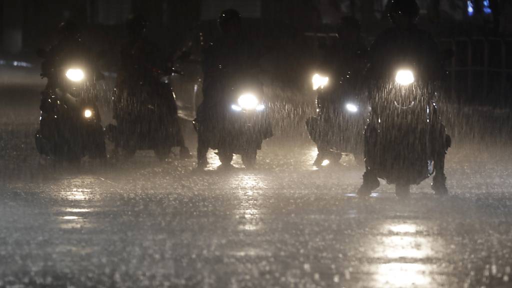 dpatopbilder - Mopedfahrer warten an einer Kreuzung in Taipeh bei starkem Regen, während sich der Taifun «Haikui» dem Land nähert. Taiwan bereitet sich im Zuge des Taifuns «Haikui» auf gefährliche Winde und starke Niederschläge vor. Wie die Regierung am Sonntag mitteilte, wurden als Präventionsmaßnahme rund 3000 Menschen auf der Insel evakuiert und in sichere Unterkünfte gebracht. Foto: Chiang Ying-ying/AP