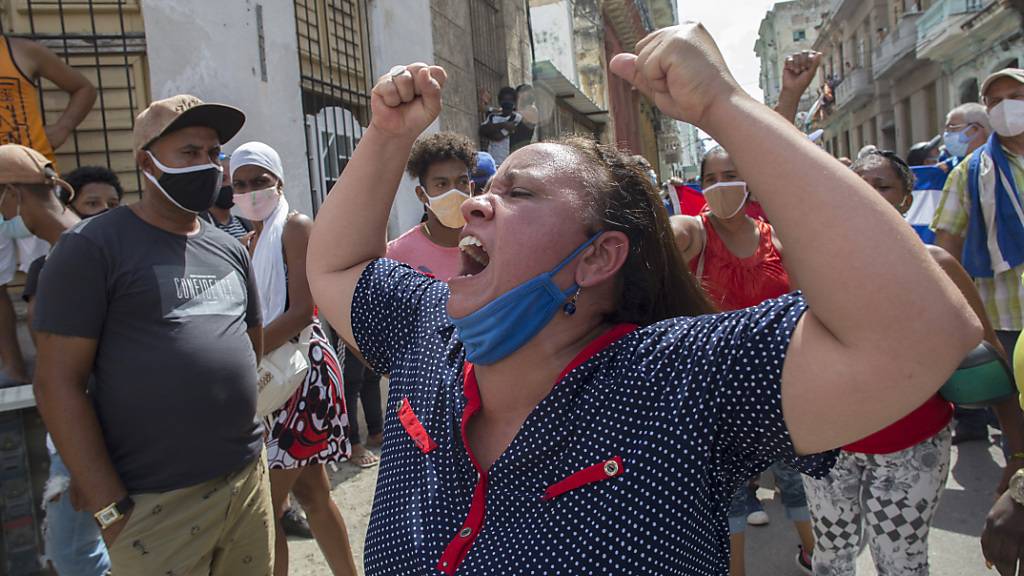 Eine Frau schreit Pro-Regierungs-Parolen, während Anti-Regierungs-Demonstranten in Havanna, Kuba, marschieren. Foto: Ismael Francisco/AP/dpa